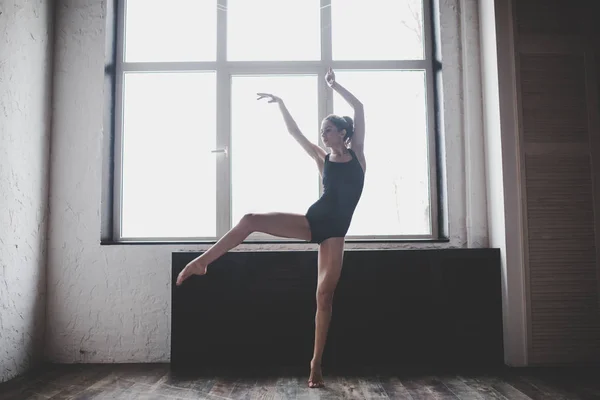 Plasticiteit slanke vrouw dansen in de buurt van venster. Professionele danser geniet van dans. Lady Dancer traint modern ballet in de klas. Hedendaagse dans performer. Daglicht, silhouet mooi lichaam. Dans thema — Stockfoto