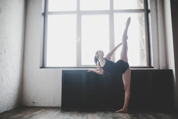 Plasticiteit slanke vrouw dansen in de buurt van venster. Professionele danser geniet van dans. Lady Dancer traint modern ballet in de klas. Hedendaagse dans performer. Daglicht, silhouet mooi lichaam. Dans thema — Stockfoto