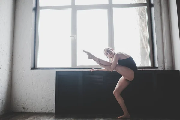 Plastyczność szczupła kobieta tańczy w pobliżu okna. Profesjonalny tancerz cieszyć się tańcem. Lady tancerz szkolenia Modern Ballet w klasie. Współczesny wykonawca tańca. Światło dzienne, sylwetka piękne ciało. Kompozycja taniec — Zdjęcie stockowe