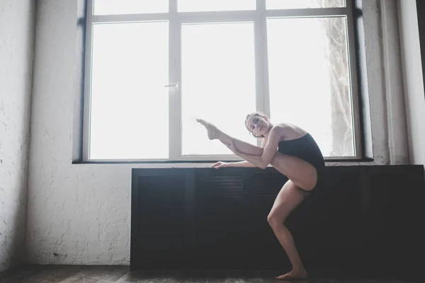 Plastisitas wanita langsing menari di dekat jendela. Penari profesional menikmati dansa. Lady Dancer Training Modern Ballet In Class (dalam bahasa Inggris). Penari kontemporer. Siang hari, tubuh indah siluet. Tema dansa — Stok Foto