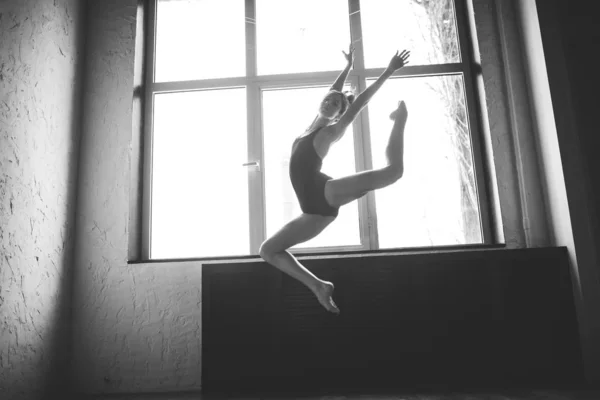 Plaszticitás karcsú nő táncol az ablak közelében. Profi táncos élvez táncol. Lady Dancer képzés modern balett osztályban. Kortárs tánc előadóművész. Nappali fény, Silhouette szép test. Tánctéma — Stock Fotó
