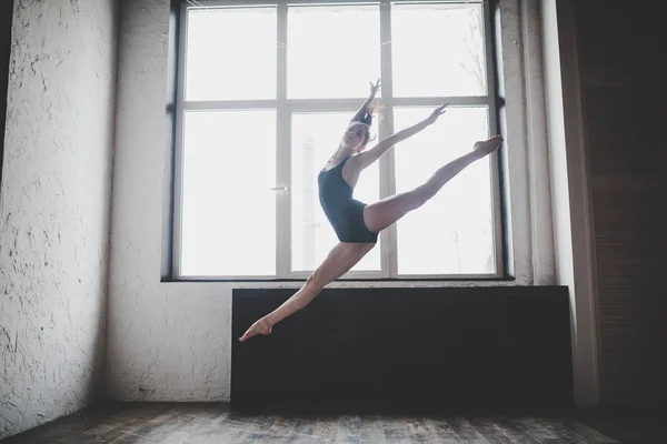 Plasticidade mulher magra dançando perto da janela. Dançarina profissional gosta de dançar. Lady Dançarina Treinando Ballet Moderno Na Classe. Artista de dança contemporânea. Luz do dia, silhueta corpo bonito. Tema da dança — Fotografia de Stock