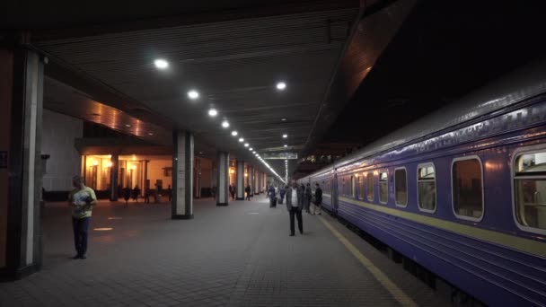 Den 7 mars 2019. Kiev. Ukraina. Central stationen. Plattform Peron Worth tåg järnväg gamla blå vagn gjorts i Sovjetunionen. Människor som går med bagage väntar på ombordstigning och avgång av tåget — Stockvideo