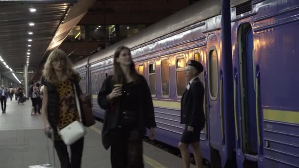 March 7, 2019. Kiev. Ukraine. Central Railway Station. Platform Peron worth train railway old blue wagon made in USSR. People walking with luggage are waiting for boarding and departure of the train — Stock Video