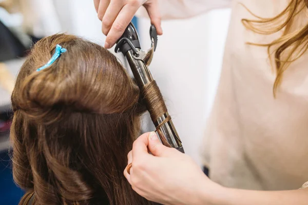 Beleza, conceito de penteado, mulher jovem feliz e cabeleireiro com ferro de cabelo fazendo penteado no salão de cabeleireiro. Mulher com cabelo cabeleireiro estilizado. Suaviza o encrespamento do cabelo. Stylist Usando Ferramenta para Modelagem — Fotografia de Stock