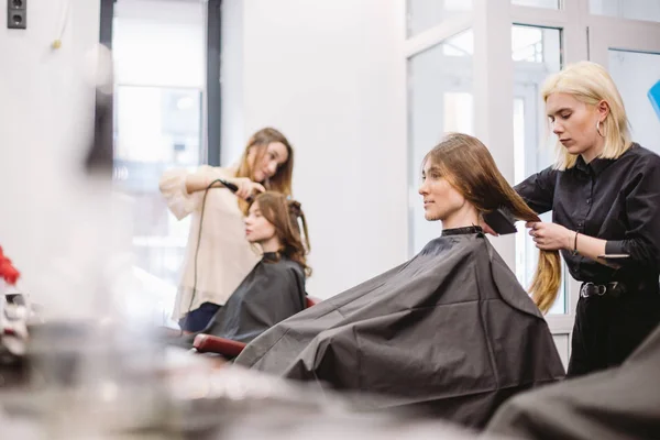 Schöne Frau kämmt nasse Haare. Stylist bürstet Frau Haare im Salon. Friseur, der Kunden bedient. professionelle junge Friseurin arbeitet mit Kamm. Haarpflegekonzept. Friseur kämmt nasse Haare — Stockfoto