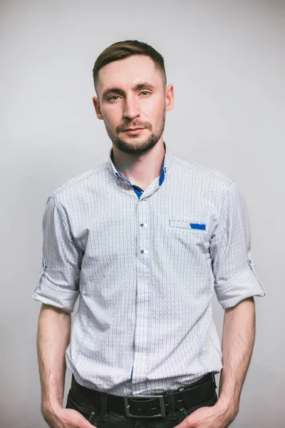 Confidence and business concept. Portrait of happy fashionable handsome man. Portrait of young handsome man in shirt looking at camera over gray background. Barbershop advertising