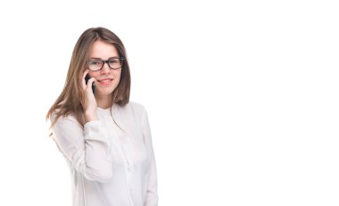Cep telefonuyla konuşan gözlüklü gülümseyen iş kadını. Beyaz izole arka plan üzerinde beyaz gömlek güzel genç kız cep telefonu konuşuyor. Cep telefonu olan gömlekli kadın. Kopya alanı. Boş