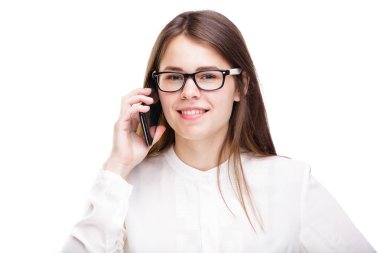 Cep telefonuyla konuşan gözlüklü gülümseyen iş kadını. Beyaz izole arka plan üzerinde beyaz gömlek güzel genç kız cep telefonu konuşuyor. Cep telefonu olan gömlekli kadın. Kopya alanı. Boş
