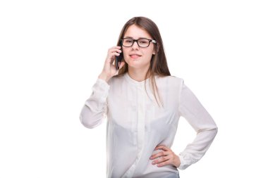 Cep telefonuyla konuşan gözlüklü gülümseyen iş kadını. Beyaz izole arka plan üzerinde beyaz gömlek güzel genç kız cep telefonu konuşuyor. Cep telefonu olan gömlekli kadın. Kopya alanı. Boş