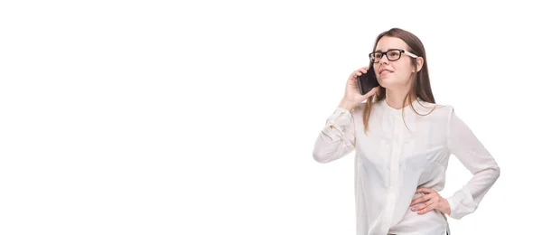 Smiling businesswoman in glasses talking on mobile phone. Beautiful young girl in white shirt on white isolated background talking on mobile phone. Woman in shirt with cellphone. Copy space. Blank — Stock Photo, Image