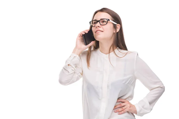 Mulher de negócios sorridente com óculos a falar no telemóvel. Menina bonita em camisa branca no fundo isolado branco falando no telefone móvel. Mulher de camisa com telemóvel. Espaço para cópia. Em branco — Fotografia de Stock