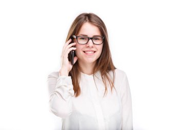Cep telefonuyla konuşan gözlüklü gülümseyen iş kadını. Beyaz izole arka plan üzerinde beyaz gömlek güzel genç kız cep telefonu konuşuyor. Cep telefonu olan gömlekli kadın. Kopya alanı. Boş