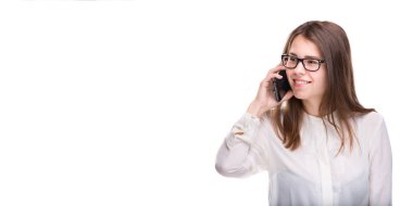 Cep telefonuyla konuşan gözlüklü gülümseyen iş kadını. Beyaz izole arka plan üzerinde beyaz gömlek güzel genç kız cep telefonu konuşuyor. Cep telefonu olan gömlekli kadın. Kopya alanı. Boş
