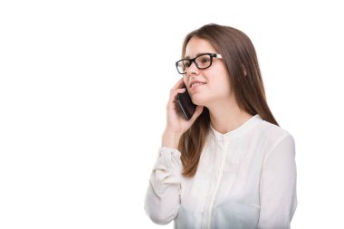 Cep telefonuyla konuşan gözlüklü gülümseyen iş kadını. Beyaz izole arka plan üzerinde beyaz gömlek güzel genç kız cep telefonu konuşuyor. Cep telefonu olan gömlekli kadın. Kopya alanı. Boş