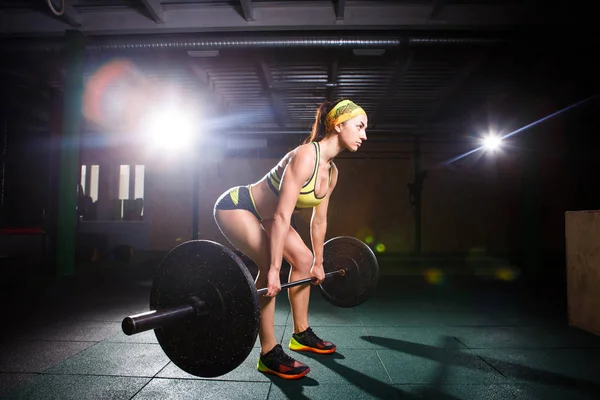 Mujer fuerte levantando la barra como parte de la rutina de ejercicios de fitness. Ajuste mujer joven levantando pesas pesadas en el gimnasio . — Foto de Stock