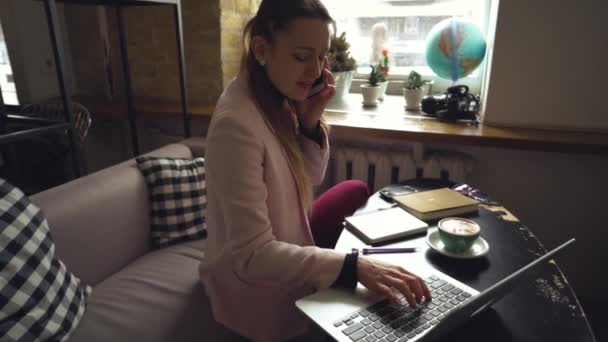 행복 한 사업가가 전화로 이야기하는 것. Woman In Cafe 는 모바일 폰을 사용하여 Notebook 을 사용 한다. 카페테리아의 여자는 핸드폰과 노트북을 사용하고 컵 커피를 마십니다. 쉬지 않고 일하는 사업가 — 비디오