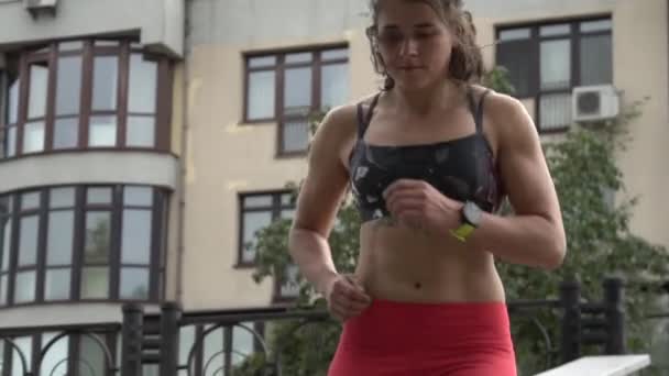 Tema idrott och en hälsosam livsstil. Ung kvinnlig idrottsman med tatuering gör cardio springa uppför trappan. uthållighetsträning och viktminskning träning urban — Stockvideo