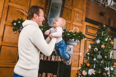 Adam ve sevimli bebek yeni yılı kutlamak için hazırız. Noel Akşamı Noel Ağacı ve Şömine Yakınında Mutlu Baba ve çocuk oğlu. tema aile tatili Yeni Yıl ve Noel