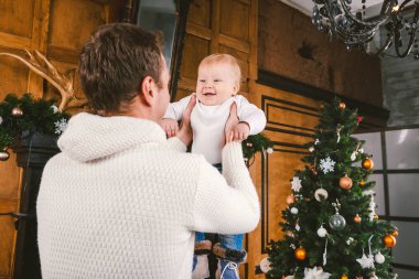 Adam ve sevimli bebek yeni yılı kutlamak için hazırız. Noel Akşamı Noel Ağacı ve Şömine Yakınında Mutlu Baba ve çocuk oğlu. tema aile tatili Yeni Yıl ve Noel