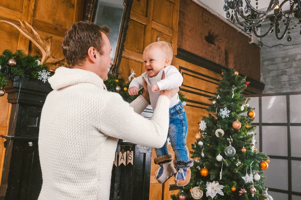 El hombre y el bebé lindo están listos para celebrar el año nuevo. Feliz padre e hijo hijo cerca del árbol de Navidad y chimenea en la noche de Navidad. tema vacaciones familiares Año Nuevo y Navidad — Foto de Stock