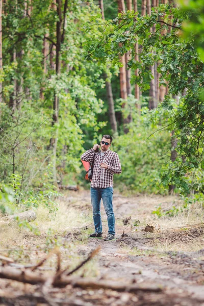 Hiker dricksvatten i skog. Trött man dricksvatten från flaska i skogsmark. Stilig resenär med ryggsäck och kolv i skog. semester, Utomhus livsstil frihet koncept. Äventyr vandring — Stockfoto