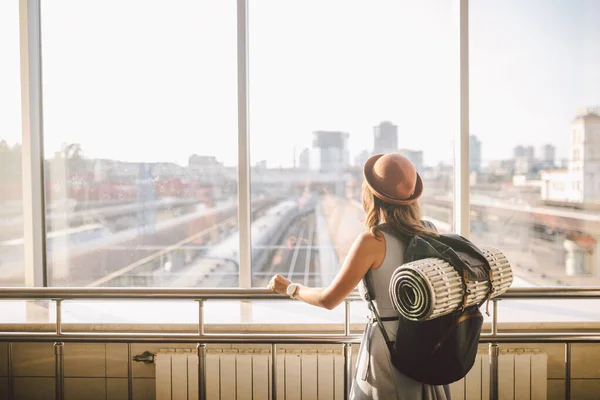Мандрівниця оглядає жінку, що стоїть біля вікна вокзалу, з рюкзаком, селективним фокусом, концепцією подорожі. транспортна концепція. Тема подорожує громадським транспортом — стокове фото