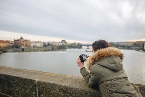 Жінка фотографує міст Карла в Празі. Молода дівчина - турист стоїть на Карловому мосту в Празі (Чехія) і фотографує чудові краєвиди міста. — стокове фото