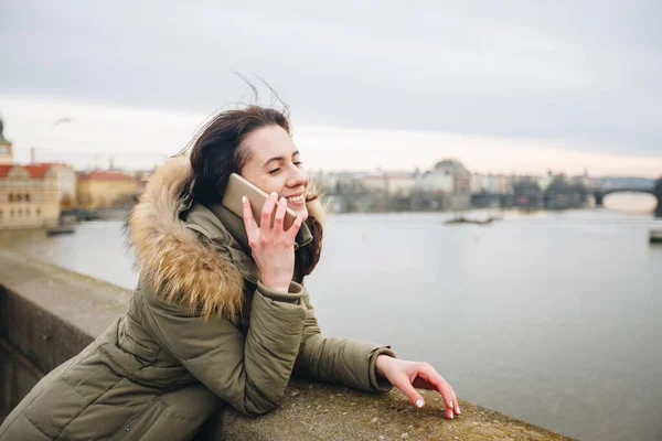 Посміхнена туристична жінка в Празі говорить на смартфоні. Молода жінка - туристка стоїть на Карловому мосту в Чеській Республіці. — стокове фото