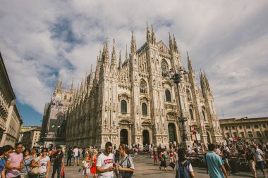 Duomo Meydanı 15 Temmuz 2017 'de İtalya' nın güneşli günlerinde kalabalık olmuştu. Kuleleri ve kalabalığı olan Duomo di Milano katedrali Piazza del Duomo meydanında yürüyor. Hıristiyanlık, Kubbe.