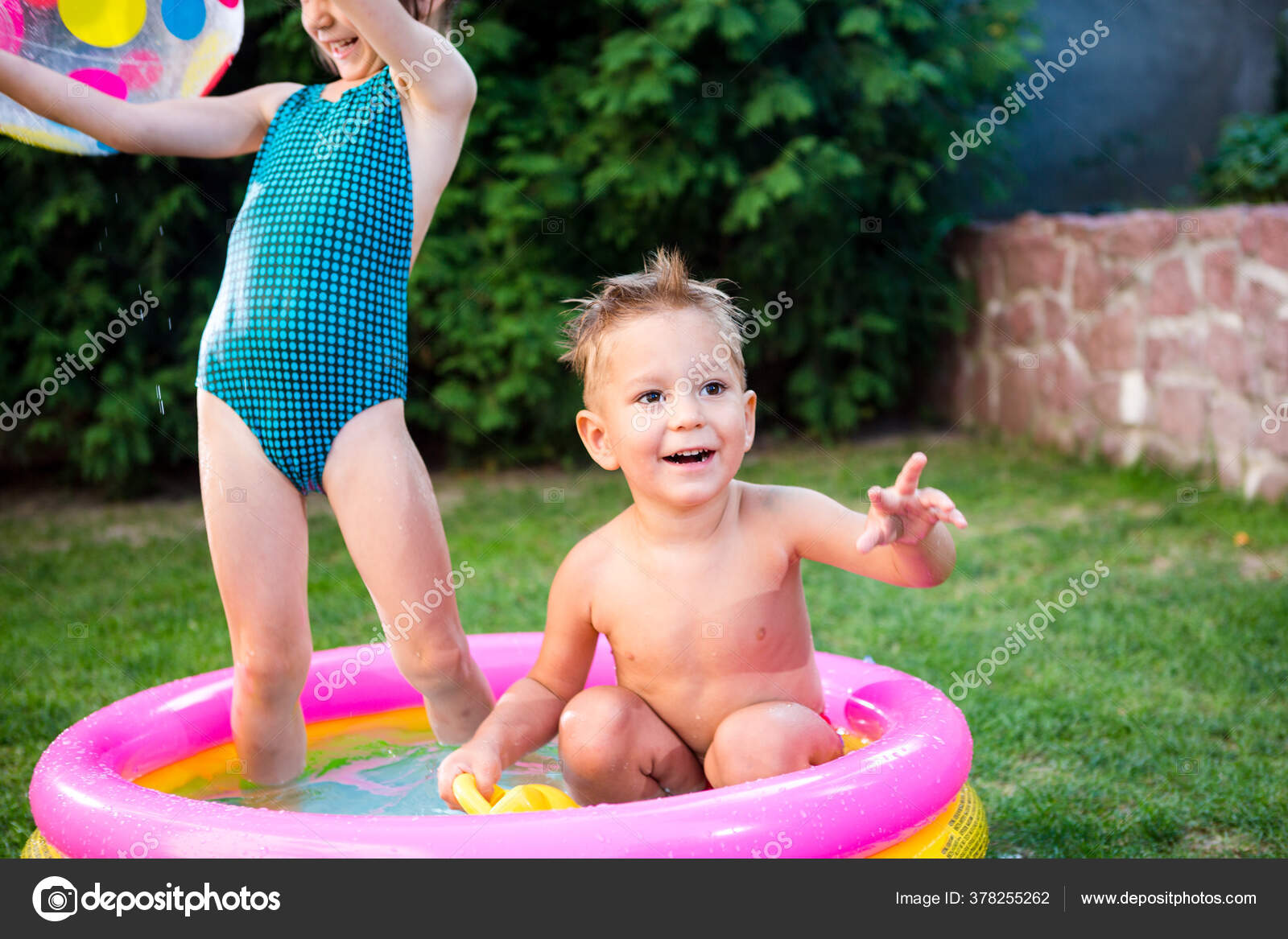 irmão com irmã jogando na piscina de bolinhas coloridas