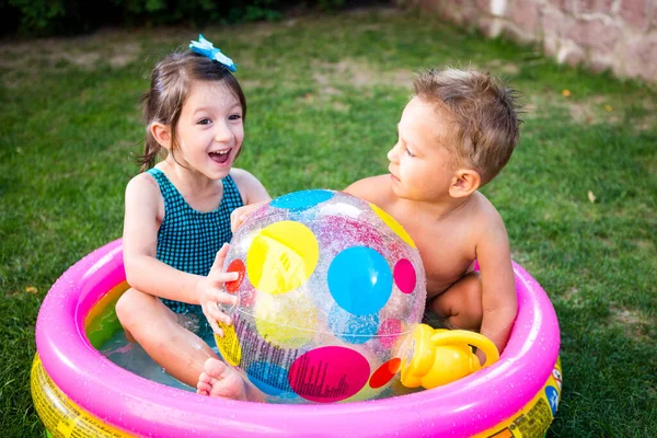 インフレータブル プール 夏休みのコンセプト 水の中のゲーム 裏庭でのレジャー 子供たちは膨脹可能な屋外スイミングプールで入浴し カラービーチボールを再生します 健康な子供の夏の活動 — ストック写真