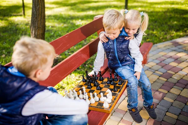 Crianças Caucasianas Jogam Xadrez Tabuleiro Xadrez Madeira Banco Parque Irmãos — Fotografia de Stock