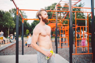 Sporcu yoğun egzersizden sonra dinleniyor, su içiyor. Genç ve güçlü sporcu erkek, spor yaparken şişeden su içiyor. Vücut sıvısına dikkat et. spor ve sağlık.