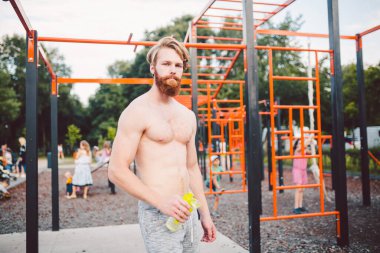 Spor salonunda su içen kaslı bir adam. Egzersiz yüzünden susuzluk ve susuzluk ve çok fazla terleme. Spor antrenmanından sonra yorgun erkek sporcu su içiyor. Fitness adamı mola veriyor..