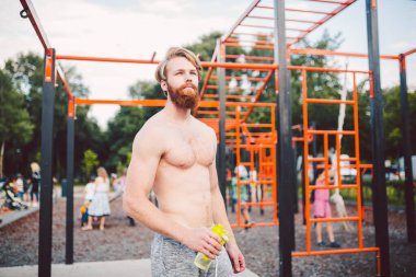 Sporcu yoğun egzersizden sonra dinleniyor, su içiyor. Genç ve güçlü sporcu erkek, spor yaparken şişeden su içiyor. Vücut sıvısına dikkat et. spor ve sağlık.