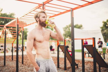 Sporcu yoğun egzersizden sonra dinleniyor, su içiyor. Genç ve güçlü sporcu erkek, spor yaparken şişeden su içiyor. Vücut sıvısına dikkat et. spor ve sağlık.