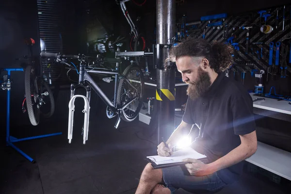 Elegante Mecánico Bicicletas Haciendo Notas Portapapeles Taller Tema Venta Pequeñas —  Fotos de Stock