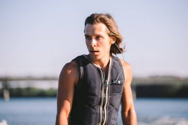 Aktif uyanış uzmanı nehir dalgalarının aşağısına atlıyor. Dalgada sörfçü. Erkek sporcu Wakesurf eğitimi alıyor. Açık havada aktif su sporları. Bir adam sörf yaparken dalga yakalar..