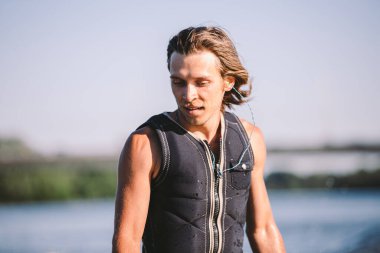 Bir adam sörf tahtasının üzerinde sörf yapıyor. Teknenin üstünde bir motorlu tekne çiziyor. Weixerfer sörf, eğlence, eğlence ve su sporlarıyla meşgul. Sporcu sörf tahtasındaki dalgalarda kayar.