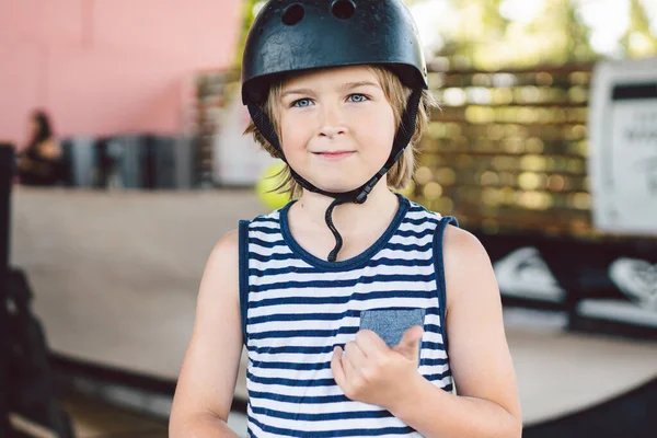 children boy with skateboard, weekend breaks, education training, first steps on board. Skateboarder boy. Smiling stylish kid youngster holding skate board outdoors. lad Looking at camera.