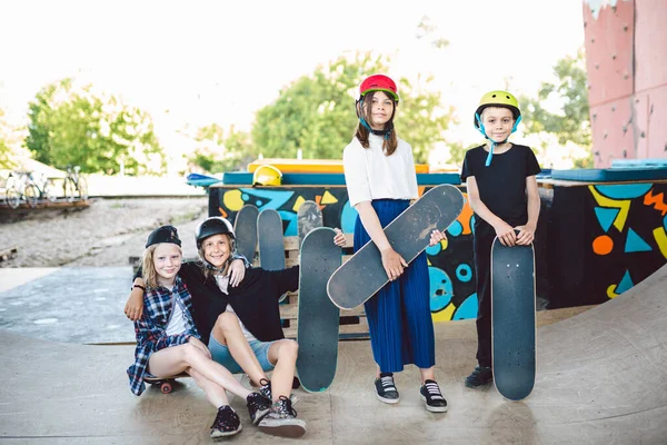 一群滑板上的孩子在城市滑板公园的斜坡上摆姿势 朋友们经常在公园里玩滑板 街头体育的游乐场 团结和友谊的概念 — 图库照片