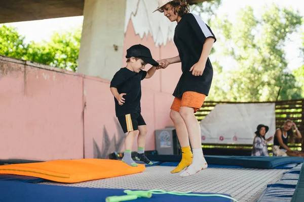 Big Brother Teaches Younger Jump Trampoline Children Active Leisure Trampolining — Stock Photo, Image