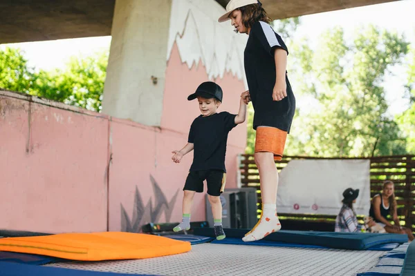 Two little boys jumping on trampoline in sport center. Kids having fun together. Active leisure. Children having fun on trampoline in entertainment center, childhood and sporty lifestyle.