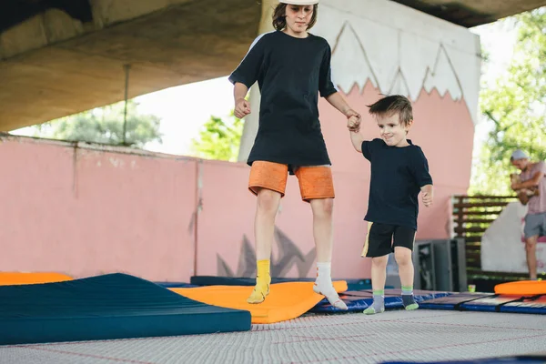 Big Brother Teaches Younger Jump Trampoline Children Active Leisure Trampolining — Stock Photo, Image