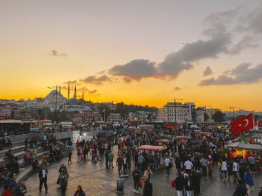 27 Ekim 2019. Eminonu Meydanı gün batımında, İstanbul 'da, Türkiye' de. Türkiye 'de Galata Köprüsü yakınlarındaki bir meydanda, İstanbul' da alışveriş ve tarihi varış noktasında insanlar dinleniyor ve sosyalleşiyor.