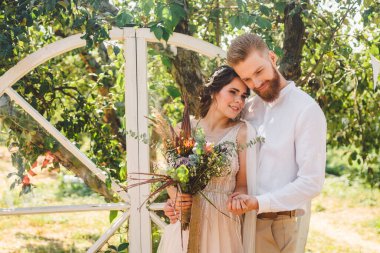 Ahşap El Hoş Geldiniz Düğün Dekorasyonu. Kırsal düğün fotoğrafı bölgesi. Düğün töreni için dekorasyon bahçesi. Güzel, genç, şehvetli bir çift romantik bir yerde yeni evliler, elma bahçesi yazı..
