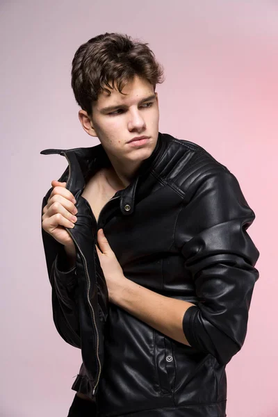 ネイキッドトルソにレザージャケットを着たハンサムなアスレチック男性モデル スタジオの赤い背景の上にバイカージャケットの中に美しい体を持つセクシーな若い男 革のコートでファッショナブルな若い男 — ストック写真