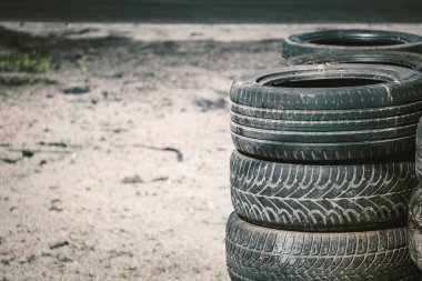 Birçok eski kullanılmış araba lastiği otomobil spor kompleksinde üst üste istiflenmiştir. Atık lastiklerin ve lastik lastiklerin işlenmesi için endüstriyel atık alanı. Eski lastik tekerlekler. Otomatikte lastikler.