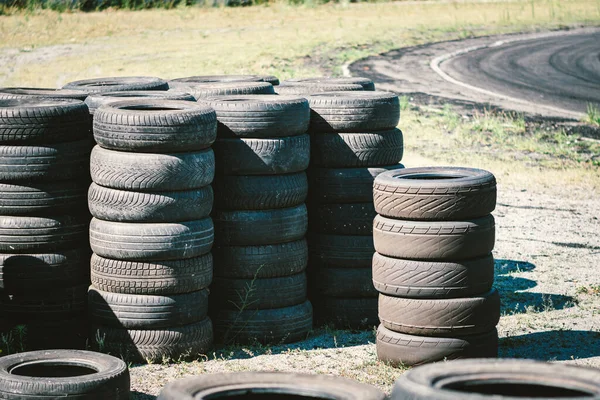 古い中古車のタイヤの多くは 自動車スポーツ複合体の上に積層 廃棄物タイヤやゴムの処理のための工業埋立地 古いゴムホイール オートドロームのタイヤ — ストック写真